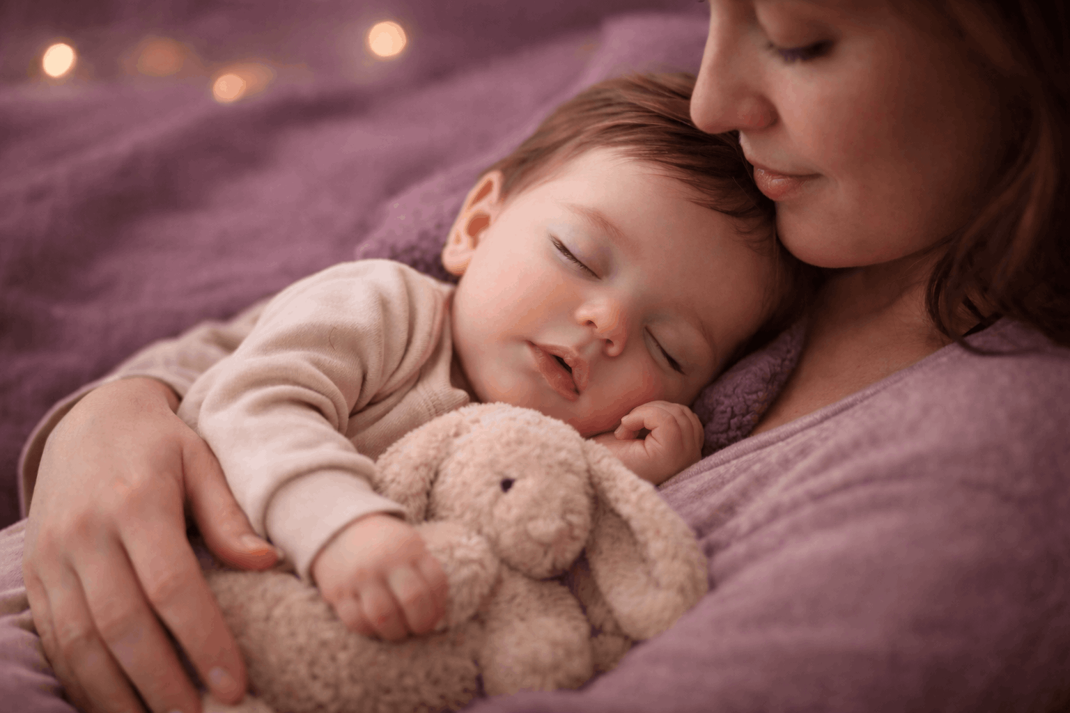 Bébé endormi dans les bras de sa maman